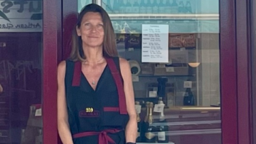 Une femme devant sa vitrine de magasin